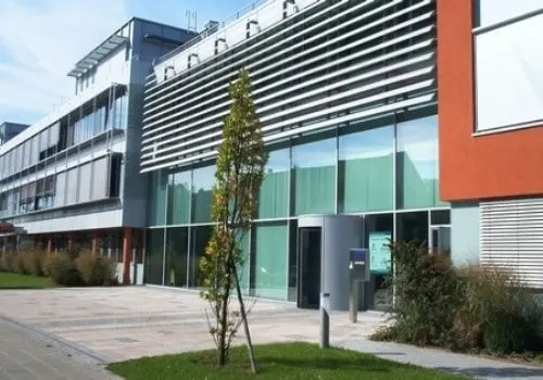 Geschäftshaus mit Sonnenschutzlamellen und Glaseingang